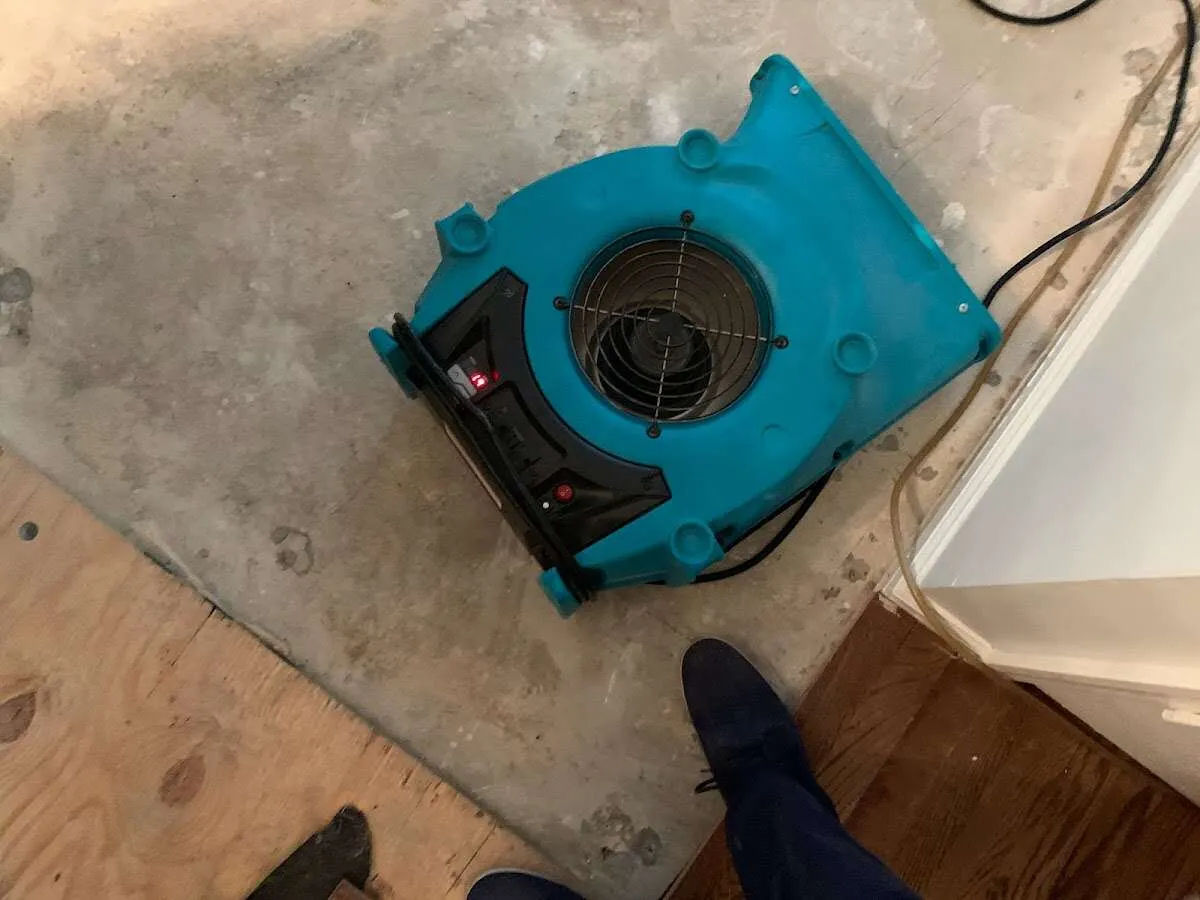 Air mover drying subfloor during Commercial Water Damage Restoration in Huntington